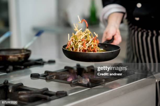 nicht erkennbare chef anbraten gemüse in einem restaurant - angebraten stock-fotos und bilder