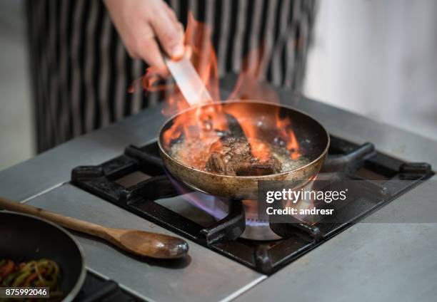 cerca de irreconocible chef usando una sartén para flambeada un filete - argentina steak fotografías e imágenes de stock