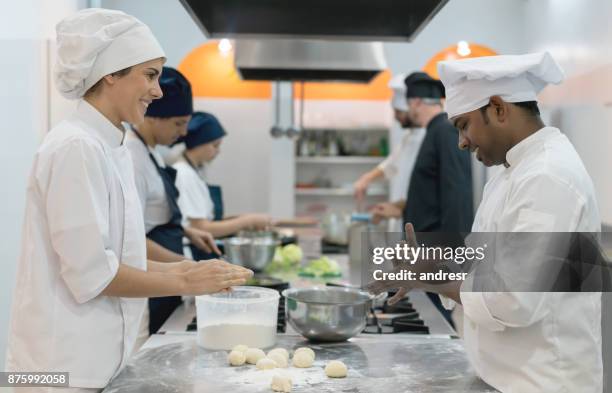 kockar knåda deg att baka bröd ser glad och leende - chef in kitchen bildbanksfoton och bilder