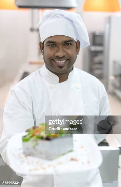 indian chef looking at camera while holding a salad he just made - arm made of vegetables stock pictures, royalty-free photos & images