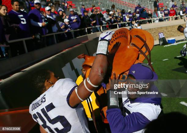 Texas Christian linebackers Travin Howard and Sammy Douglas lift the West Texas Championship Saddle in victory after the Texas Tech Raider's 27-3...