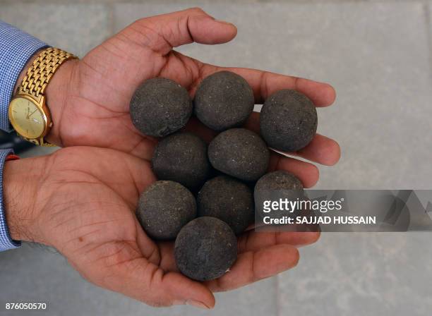 In this photograph taken on November 15 Sulabh International Museum of Toilets scientist R.C Jha displays balls made from human waste during an...