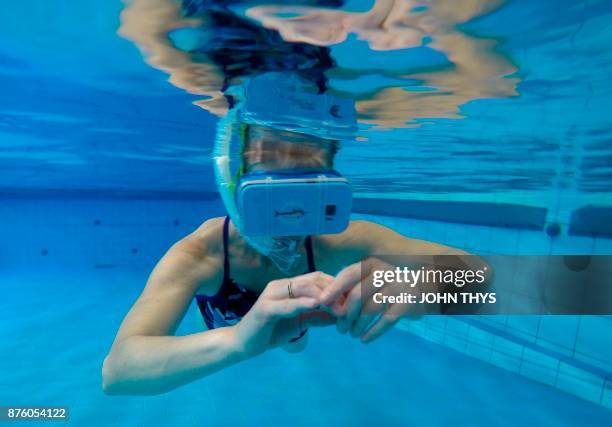 Therapist tests out new cutting-edge waterproof virtual reality glasses playing a film of dolphins, at the 'S Heeren Loo care centre for disabled...
