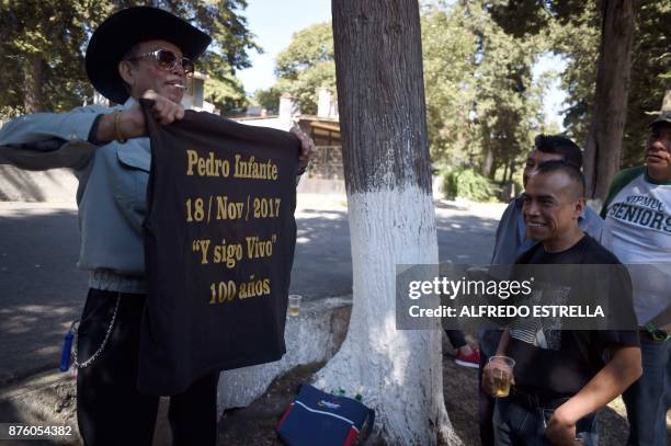 Man depicted Mexican singer and actor Pedro Infante shows a t-shirt to visitors during the 100th Anniversary of his birth, at the Panteon Jardin, in...