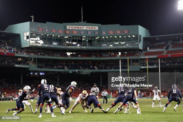 David Pindell of the Connecticut Huskies hands the ball off to Kevin Mensah during the second half against the Boston College Eagles at Fenway Park...