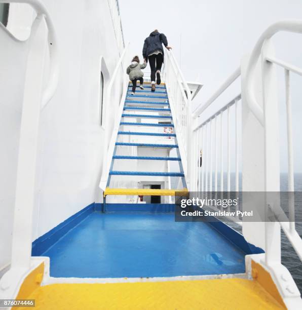 mother with daughter walking on colorful stairs on ferry - ferry photos et images de collection