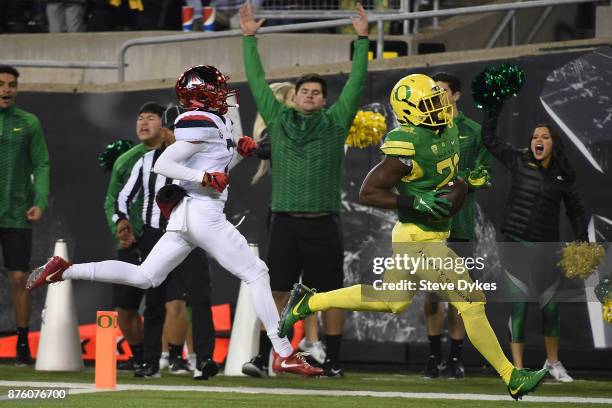 Running back Royce Freeman of the Oregon Ducks scores a touchdown as cornerback Lorenzo Burns of the Arizona Wildcats gives chase during the first...