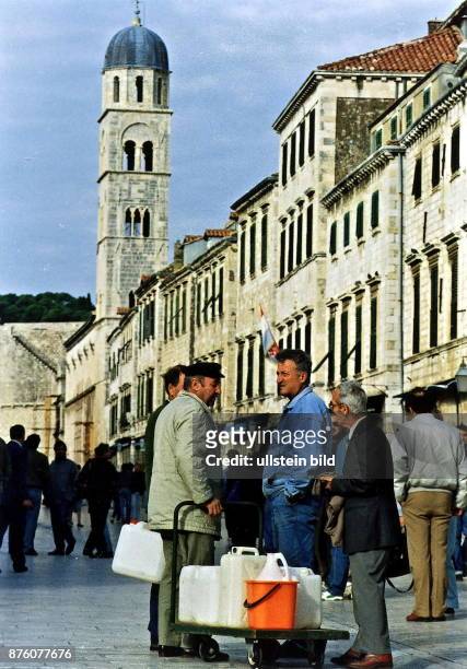 In der Altstadt von Dubrovnik sind Männer mit einem Handkarren und Plastikkanistern zum Wasserholen unterwegs. Juni 1992
