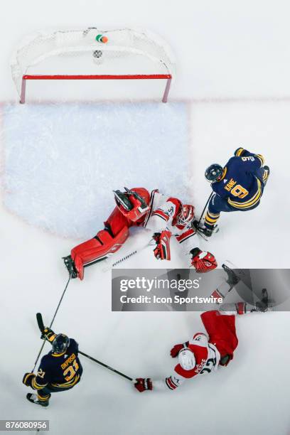 Carolina Hurricanes Goalie Scott Darling sprawls on the ice as Buffalo Sabres Left Wing Evander Kane , Carolina Hurricanes Defenseman Brett Pesce ,...