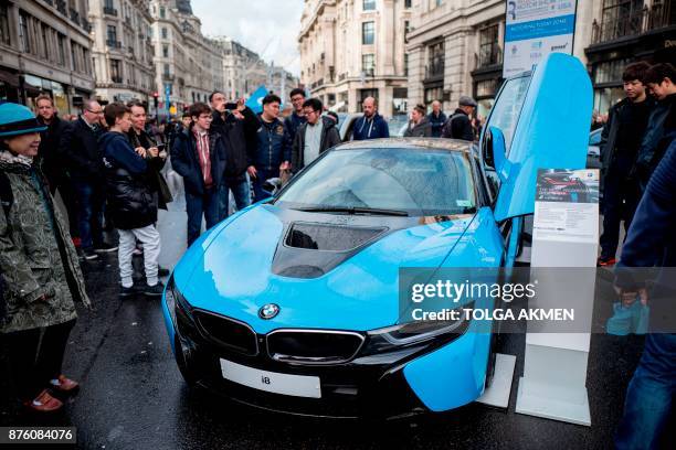 Visitors look at a BMW i8 plug-in hybrid sports car during the Regent Street Motor Show in London on November 4, 2017. - A driverless, electric car...