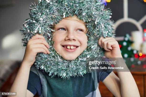 child with a wreath of tinsel - naughty christmas ornaments stock pictures, royalty-free photos & images