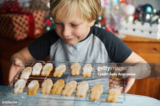 child holding a tray of gingerbread men biscuits - bakplåt bildbanksfoton och bilder