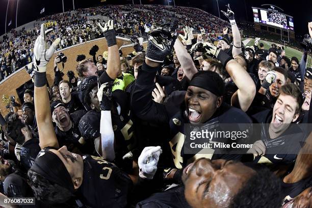 The Wake Forest Demon Deacons celebrate an upset victory over the North Carolina State Wolfpack following the football game at BB&T Field on November...