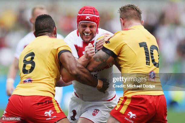 Chris Hill of England is tackled by Moses Meninga and Luke Page of Papua New Guinea during the 2017 Rugby League World Cup Quarter Final match...