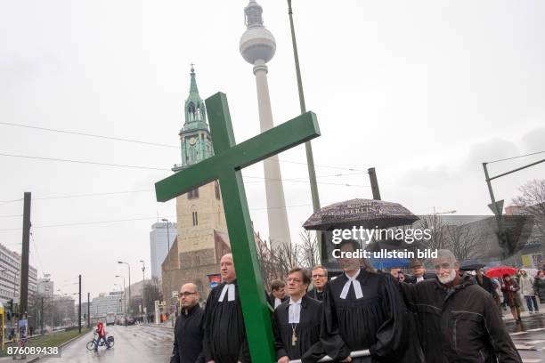 Karfreitagsprozession anlässlich des Osterfestes von der Berliner Marienkriche zum Französischen Dom - Der syrische Flüchtling Jalal Aldebes trägt...