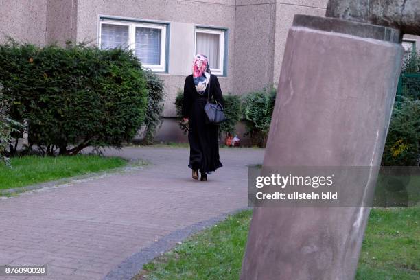 Frau mit einem Kopftuch auf dem Gehweg in Berlin-Wedding