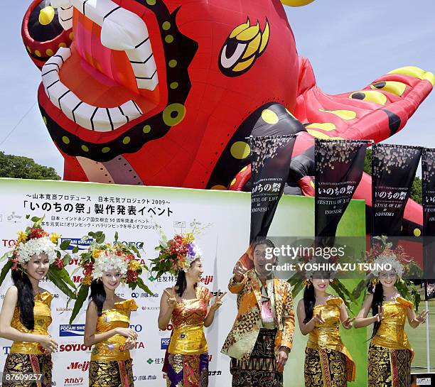 Japanese famous fashion designer and event producer Kansai Yamamoto smiles with Japanese actress Rei Kikukawa and Indonesian models in traditional...