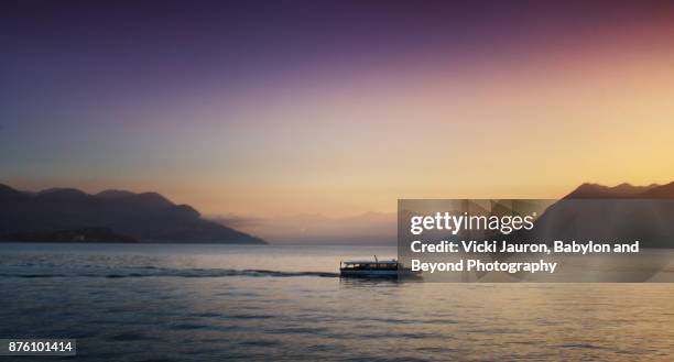 ferry boat at sunrise on lake maggiore, italy - isola bella stock-fotos und bilder