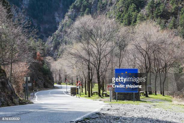 blue road sign with yellow stars in the border area between andorra and spain - andorra stock pictures, royalty-free photos & images
