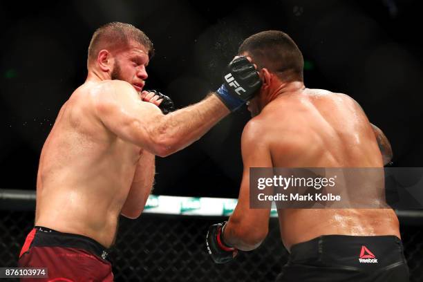 Marcin Tybura of Poland punches Fabricio Werdum of Brazil in their heavyweight bout during the UFC Fight Night at Qudos Bank Arena on November 19,...