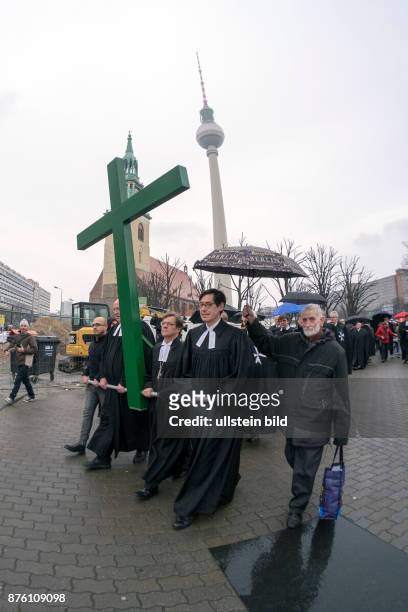 Karfreitagsprozession anlässlich des Osterfestes von der Berliner Marienkriche zum Französischen Dom - Der syrische Flüchtling Jalal Aldebes trägt...