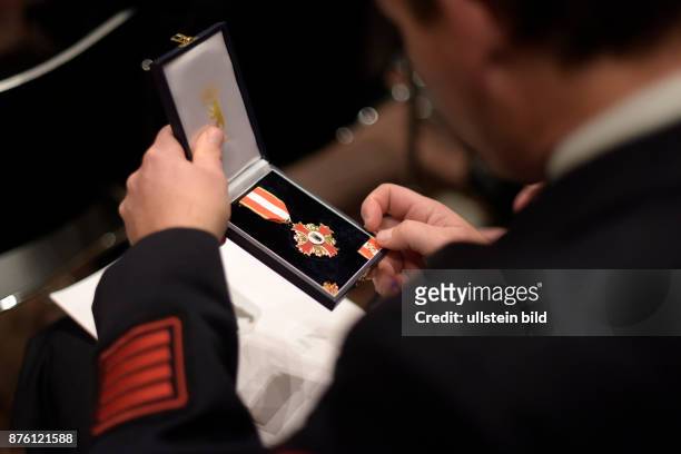 Geehrter Feuerwehrmann mit seiner Auszeichnung bei der Verleihung des Katastrophenschutz-Ehrenzeichens der Stufe II für langjährige Mitarbeit und...