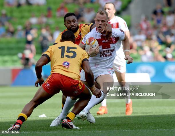 Englands Kevin Brown is tackled by Justin Olam and Stargroth Amean of Papua New Guinea during their Rugby League World Cup quarter-final match...