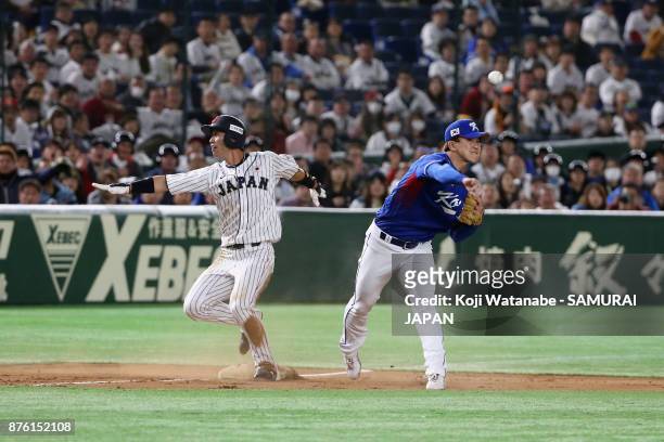 Infielder Shuta Tonosaki of Japan is forced out while Infielder Jung Hyun of South Korea throws to the first base to make a double play in the bottom...