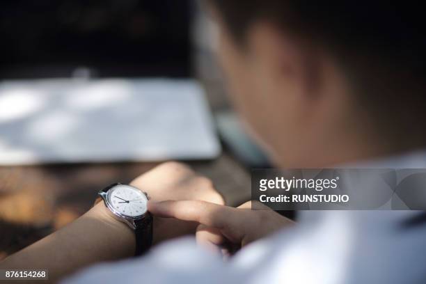 businessman checking the time on his watch - checking the time stock pictures, royalty-free photos & images