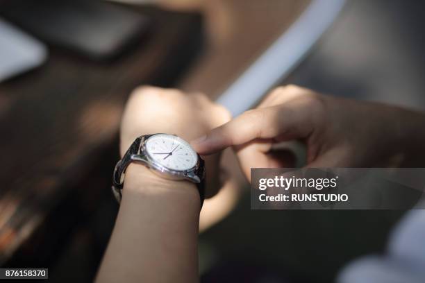 close-up of businessman outdoors checking the time - armbanduhr stock-fotos und bilder