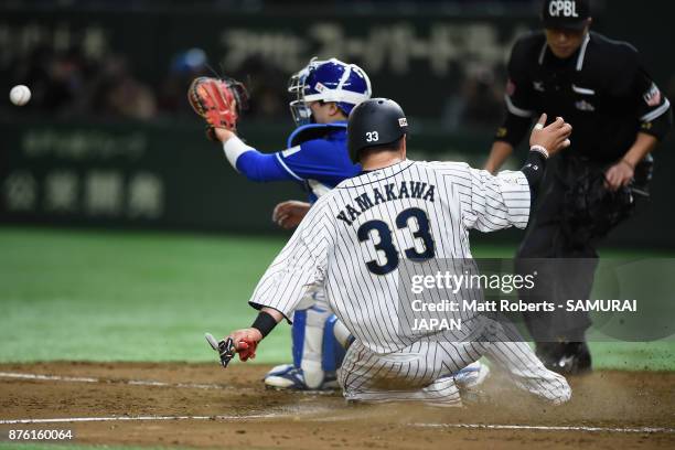 Infielder Hotaka Yamakawa of Japan slides into the home plate to score a run to make it 1-0 by the RBI double of Infielder Shuta Tonosaki of Japan in...