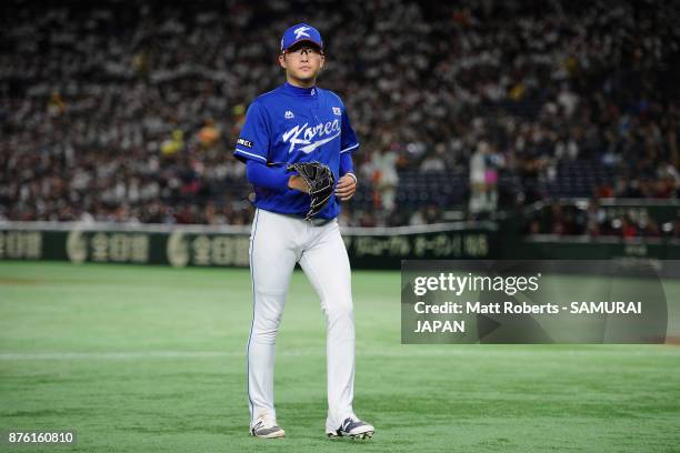 Pitcher Park Sewoong of South Korea walks to the dugout as he is withdrawn after the RBI double by Infielder Shuta Tonosaki of Japan in the bottom of...