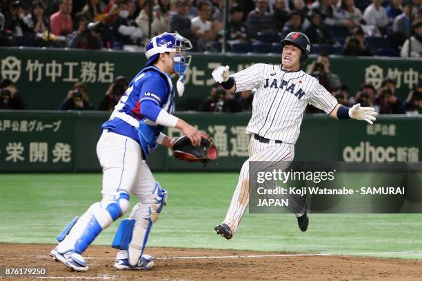 Infielder Shuta Tonosaki of Japan slides to the home plate to score a run to make it 4-0 after the two run double by Infielder Ryoma Nishikawa in the...