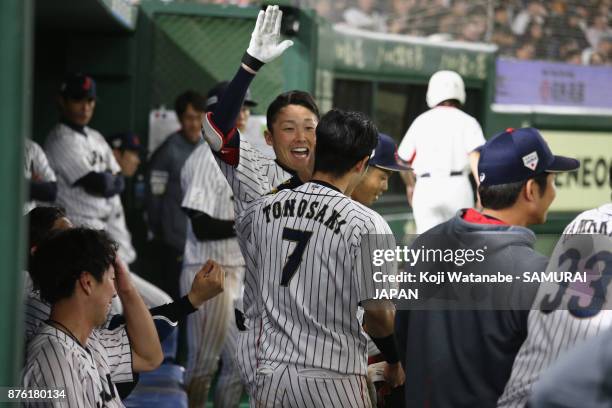 Infielder Shuta Tonosaki of Japan is congratulated by team mates in the dugout in the bottom of fifth inning during the Eneos Asia Professional...