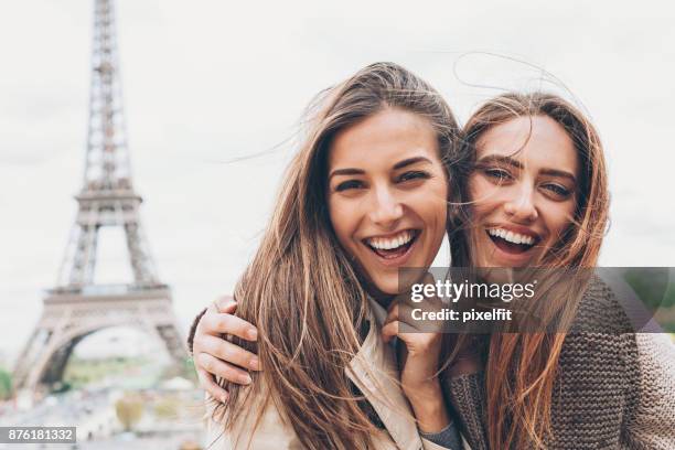 gelukkig vriendinnen met eiffeltoren - cute girlfriends stockfoto's en -beelden