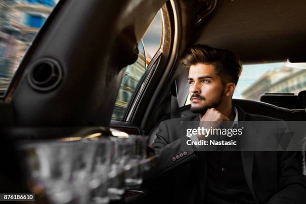 young businessman driving through city - luxury watch stock pictures, royalty-free photos & images