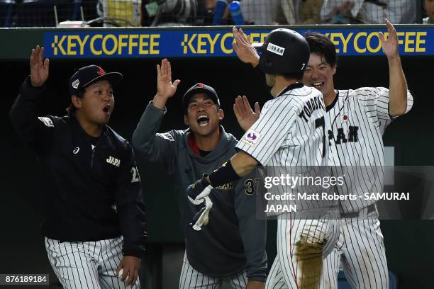 Infielder Shuta Tonosaki of Japan high fives with team mates after scoring a run during the Eneos Asia Professional Baseball Championship 2017 final...