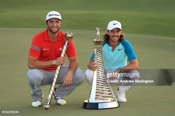 Jon Rahm of Spain poses with the trophy and Tommy Fleetwood of England poses with the Race to Dubai trophy during the final round of the DP World...