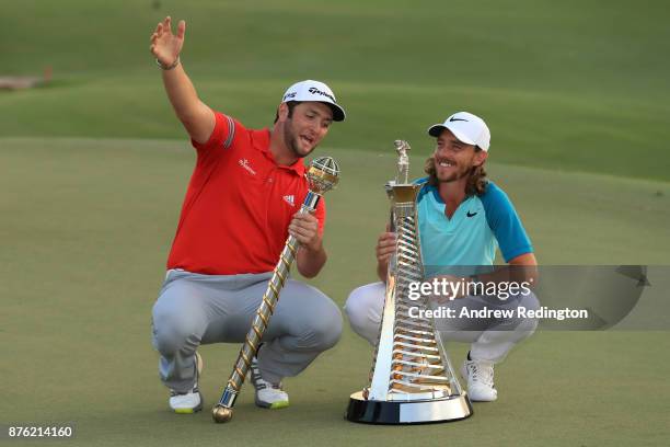 Jon Rahm of Spain poses with the trophy and Tommy Fleetwood of England poses with the Race to Dubai trophy during the final round of the DP World...