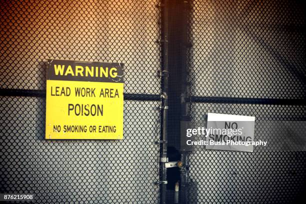 "lead work area" warning sign outside chain link fence in manhattan, new york city - graphite stock pictures, royalty-free photos & images
