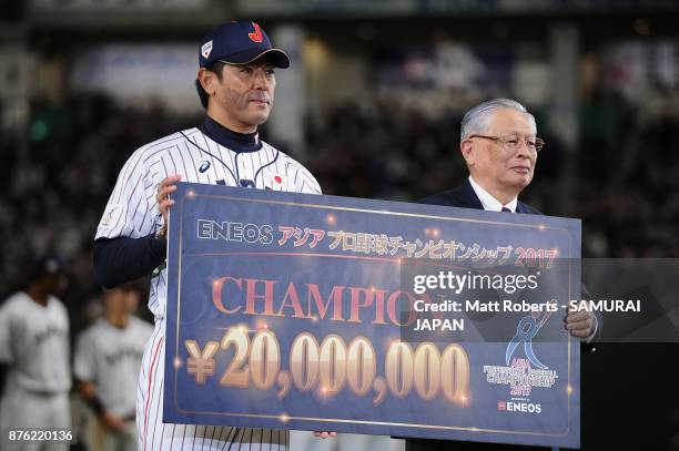 Head coach Atsunori Inaba of Japan poses for photographs with the Nippon Professional Baseball Commissioner Katsuhiko Kumazaki at the award ceremony...