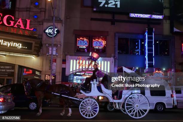 night street scene in midtown manhattan: horse carriage ride along a busy west 42nd street. new york city, usa - ride along filme - fotografias e filmes do acervo