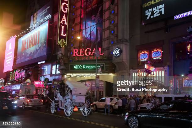 night street scene in midtown manhattan: horse carriage ride along a busy west 42nd street. new york city, usa - ride along filme - fotografias e filmes do acervo