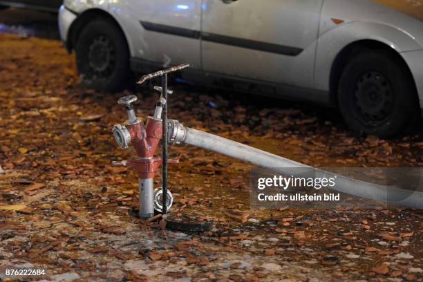 Standrohr in einem Hydranten auf einem mit heruntergefallenen Dachziegeln übersähten Gehweg - Löscharbeiten während eines Dachstuhlbrandes in der...