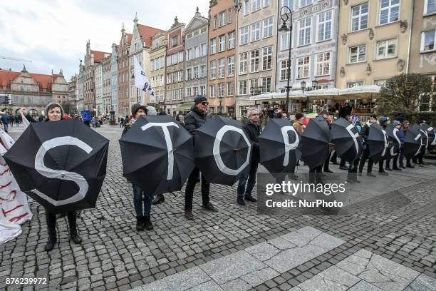 Anti-fascist rally participants with STOP Fascism inscription painted on black umbrellas are seen in Gdansk, Poland on 19 November 2017 People...