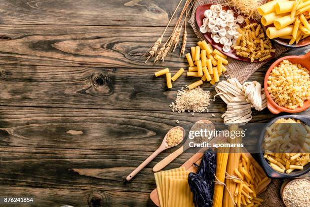 pasta italiana en la rústica mesa de madera en una cocina - carbohidrato fotografías e imágenes de stock