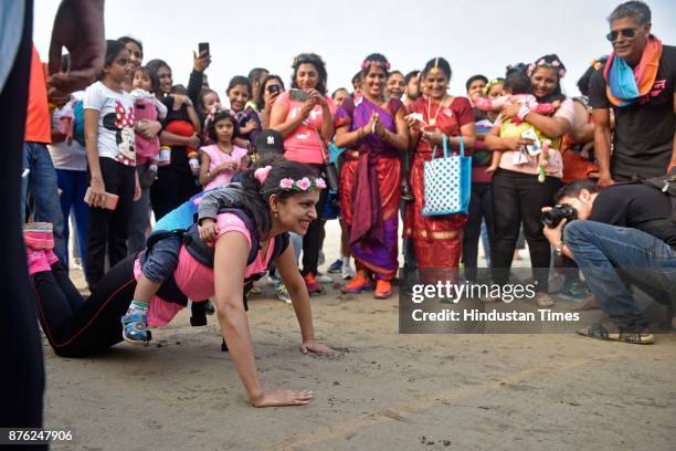 Actor and model Milind Soman and Women with their babies participate in Baby-Wearing Super Moms event organised by by Colors Pinkathon at Juhu Beach,...