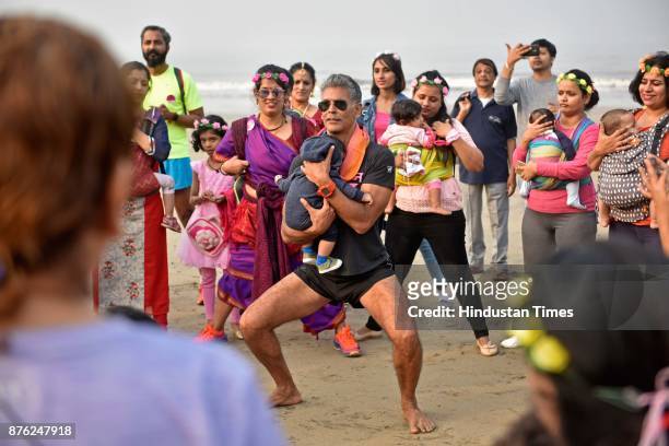 Actor and model Milind Soman and Women with their babies participate in Baby-Wearing Super Moms event organised by by Colors Pinkathon at Juhu Beach,...