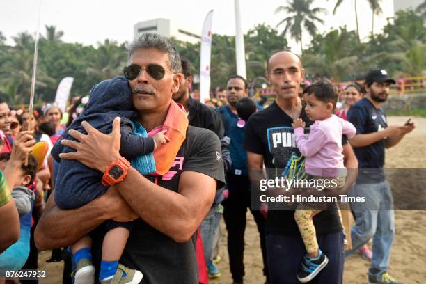 Actor and model Milind Soman and Women with their babies participate in Baby-Wearing Super Moms event organised by by Colors Pinkathon at Juhu Beach,...