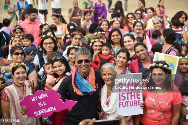 Actor and model Milind Soman and Women with their babies participate in Baby-Wearing Super Moms event organised by by Colors Pinkathon at Juhu Beach,...